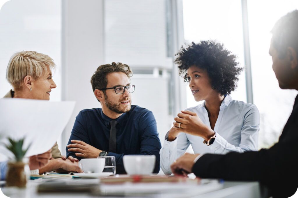 4 people sitting in a board room