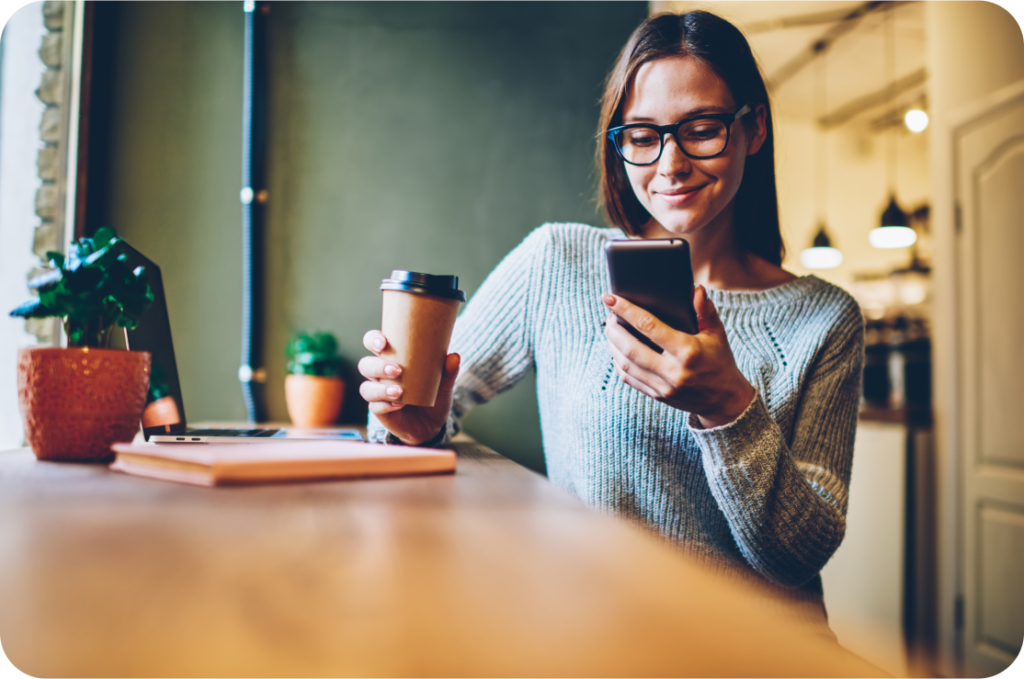 woman holding phone and coffee